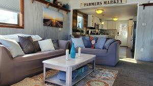 uma sala de estar com dois sofás e uma mesa em Airport Waterfront Cottage w transportation em Alto