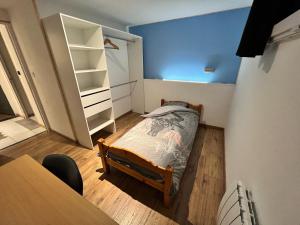 een kleine slaapkamer met een bed en een bureau bij Maison calme pour 6 personnes in Mouilleron-le-Captif