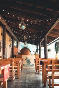 Koltincalli في Xico: مطعم بطاولات ومقاعد خشبية وعلامة
