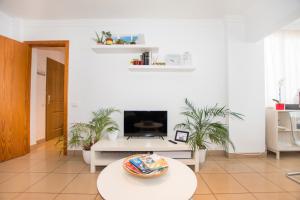 sala de estar con mesa y TV en House Canteras Castillo de la Luz, en Las Palmas de Gran Canaria