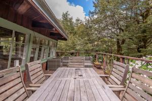 a wooden table and chairs on a deck at Holiday Chalet in Arthurs Pass in Arthur's Pass