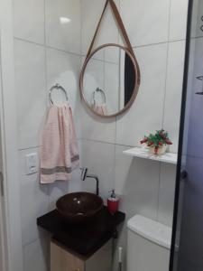 a bathroom with a sink and a mirror and a toilet at Apartamento Cantinho do Aconchego-Nova Petrópolis in Nova Petrópolis