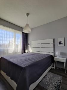 ein Schlafzimmer mit einem großen Bett und einem Fenster in der Unterkunft Sweet family apartments Hamina in Hamina