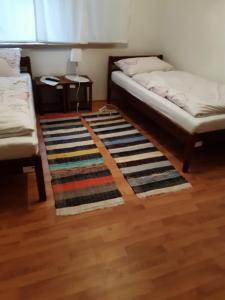 Habitación con 2 camas y alfombra en el suelo en Etno Ana, 