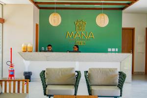 Dois homens sentados num bar num restaurante. em Mana Beach Experience By Mai em Porto de Galinhas