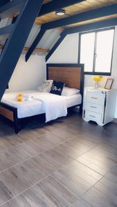 1 dormitorio con cama blanca y suelo de madera en Lovely tiny studio, en Jarabacoa