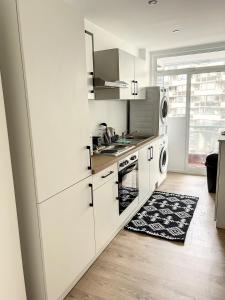 a kitchen with white cabinets and a stove top oven at tirou 3 centre Brussels-charleroi-airport in Charleroi