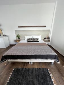 a bedroom with a large bed with a black rug at Fatolitis Studios in Masouri