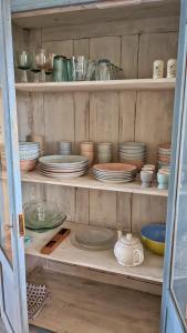 a shelf with plates and bowls and other dishes at Vita Nova in Hippolytushoef