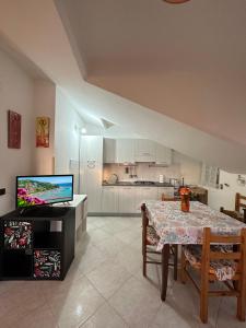a living room with a dining room table and a television at Tramonto sul Mare in Agropoli
