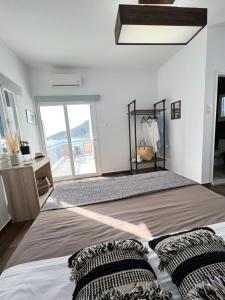 a bedroom with a large bed and a large window at Fatolitis Studios in Masouri