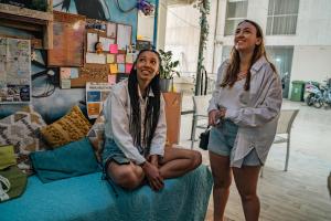 two women are standing next to a bed at Marina Ben Gurion Hostel in Tel Aviv