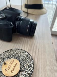 a camera on a table next to a wooden plate with a label at Fatolitis Studios in Masouri