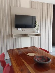 mesa de comedor con TV en la pared en PICURÙ DUPLEX en Puerto Iguazú