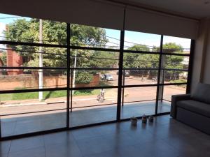 sala de estar con ventana grande y sofá en PICURÙ DUPLEX en Puerto Iguazú