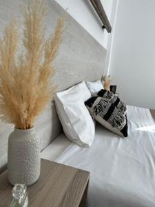 a bed with two pillows and a vase on a table at Fatolitis Studios in Masouri