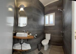 a bathroom with a sink and a toilet and a mirror at Fatolitis Studios in Masouri