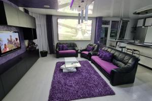 a living room with purple furniture and a purple rug at MeLux Airport House 