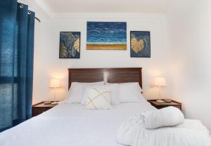 1 dormitorio con 1 cama blanca y 2 lámparas en House Canteras Castillo de la Luz, en Las Palmas de Gran Canaria