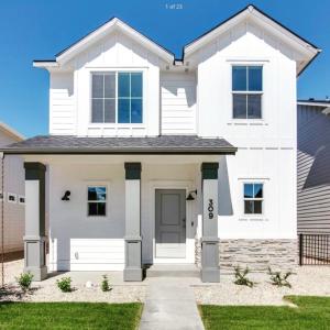 a white house with a driveway at Hygee House Brand New Construction near Ford Idaho Center and I-84! Plush and lavish furniture, warm tones to off-set the new stainless appliances, play PingPong in the garage or basketball at the neighborhood park in Meridian