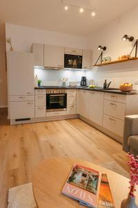 a kitchen with white cabinets and a wooden floor at Holt Stuuv in Ratzeburg