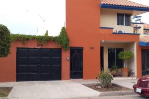 uma casa laranja com uma porta de garagem preta em Tu depa en Los Mochis em Los Mochis