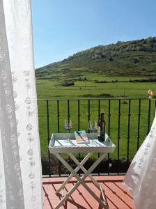 una mesa con 2 copas de vino en el balcón en VILLA CARMEN. coqueto apartamento con piscina y garaje, en Ezcaray