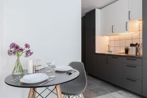 a dining room with a table and chairs and a kitchen at River To The City - Studio 7b Apartment in Vilnius