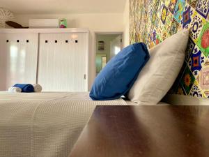 a bedroom with a bed with a blue pillow on it at Casa María in Isla Mujeres