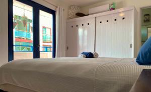 a bedroom with a large white bed with a window at Casa María in Isla Mujeres