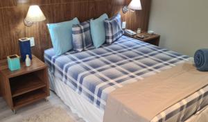 a bedroom with a large bed with blue pillows at Lindíssimo Flat em Taguatinga. Conforto, tranquilidade e paz em um ambiente perfeito. in Brasilia