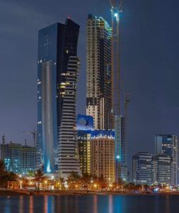 Damac Al Jawharah Tower Apartments في جدة: أفق المدينة في الليل مع المباني الطويلة