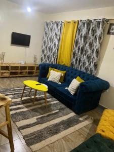 sala de estar con sofá azul y mesa amarilla en Ruby Modern Homes-2br-Nyeri, King'ong'o-Knights en Nyeri