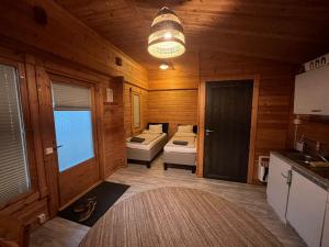 a room with two beds in a wooden cabin at Cottage by the sea in Hanko