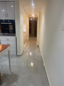 a kitchen with white cabinets and a tile floor at One bedroom apartment at marina city portghalib in Port Ghalib