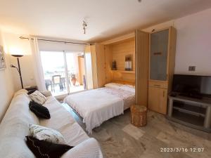 ein Wohnzimmer mit 2 Betten und einem TV in der Unterkunft APARTAMENTOS LOS HIDALGO GOLF in Manilva