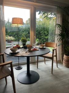 een tafel met kommen in een kamer met een raam bij Luxe vakantiehuis “Saalien” in Beekbergen