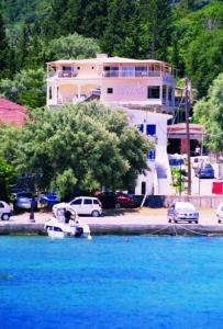 a boat in the water in front of a building at Hotel Pegasos in Nikiana