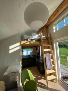 a room with a loft bed in a tiny house at Minihus med drømmeutsikt til Sunnmørsalpene in Aure