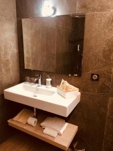 ein Bad mit einem Waschbecken und einem Spiegel in der Unterkunft Auberge Quintessence in Roubion