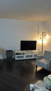 a living room with a flat screen tv on a white entertainment center at Ft Lauderdale Jewel in Fort Lauderdale