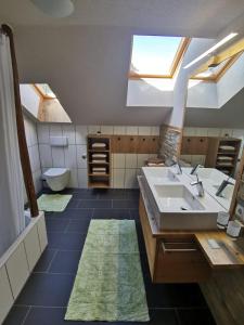 een badkamer met een wastafel, een toilet en dakramen bij Haus Viktoria in Mayrhofen