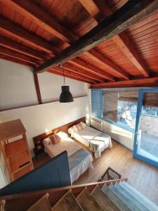 a bedroom with two beds and a large window at Casa Albarrana in Talavera de la Reina