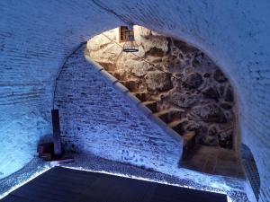 un túnel subterráneo con una pared de piedra y escaleras en Casa Albarrana, en Talavera de la Reina