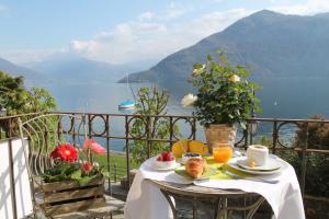 einen Tisch mit Speisen und Blick auf das Wasser in der Unterkunft Spiaggia Amore - Appartamenti Vacanza Vista Lago in Cannobio