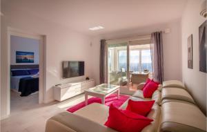 - un salon avec un canapé et des oreillers rouges dans l'établissement Nice Apartment In El Poble Nou De Benita With Kitchen, à Cumbre del Sol