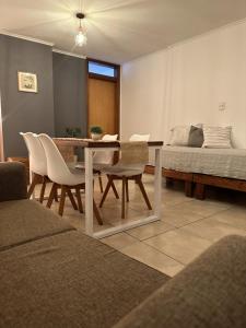 ein Wohnzimmer mit einem Tisch, Stühlen und einem Bett in der Unterkunft Dpto Paraná - Piscina, calefacción y aire acond in Cordoba