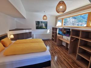 een slaapkamer met een bed en een groot raam bij Haus Viktoria in Mayrhofen