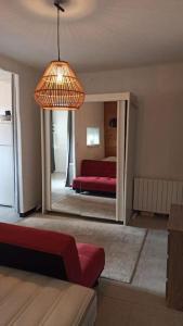 a living room with a mirror and a red bed at Vogué meublé 2 étoiles, Un Cocon pour 2 in Vogüé +9 photos