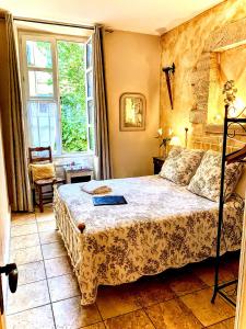 Un dormitorio con una cama con un libro. en La Lanterne Chambres d'Hotes, en Sarlat-la-Canéda